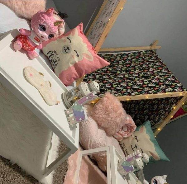 A girl's room with stuffed animals and a teepee.