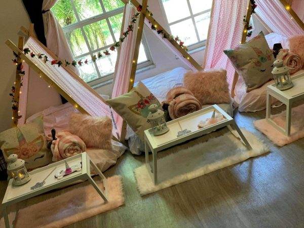 A colorful party room adorned with pink decorations and teepees, perfect for a Slime Party in Lakeland.