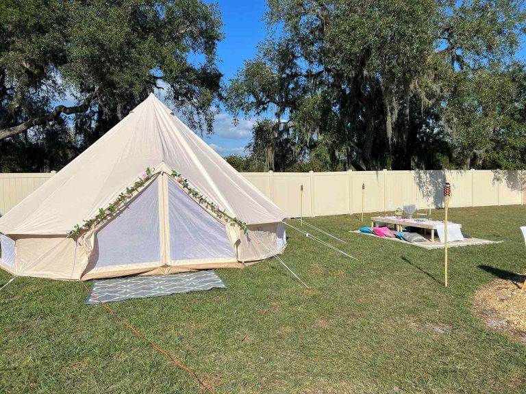 A white teepee is set up in a Lakeland backyard, creating the perfect glamping experience.