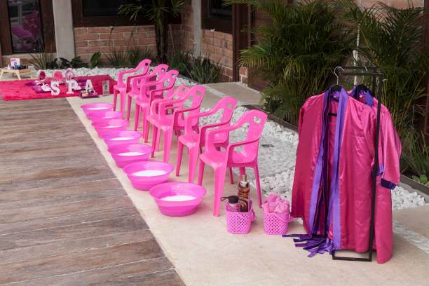 Pink chairs and accessories arranged for an outdoor home spa-themed party setting.