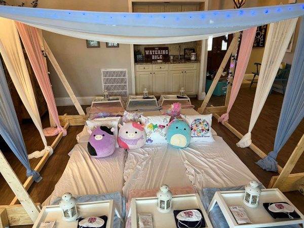 Ultimate Canopy Slumber Party setup with lined mattresses, canopies, and decorative pillows, accompanied by bedside lanterns and trays.