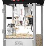 A commercial popcorn machine with a clear glass enclosure and stainless steel base, filled with freshly popped popcorn, perfect for birthday party add-ons.