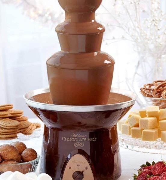 A Chocolate Fountain Rental with flowing chocolate, surrounded by various dipping treats including strawberries, marshmallows, and cookies.
