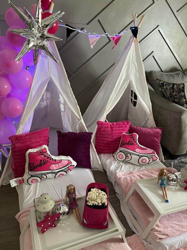 A pink teepee decorated with pink pillows for a glamping party.