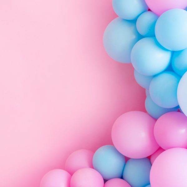 Blue and pink Jubilee balloon garland arranged on the left side of a pastel pink background, suitable for party decorations.