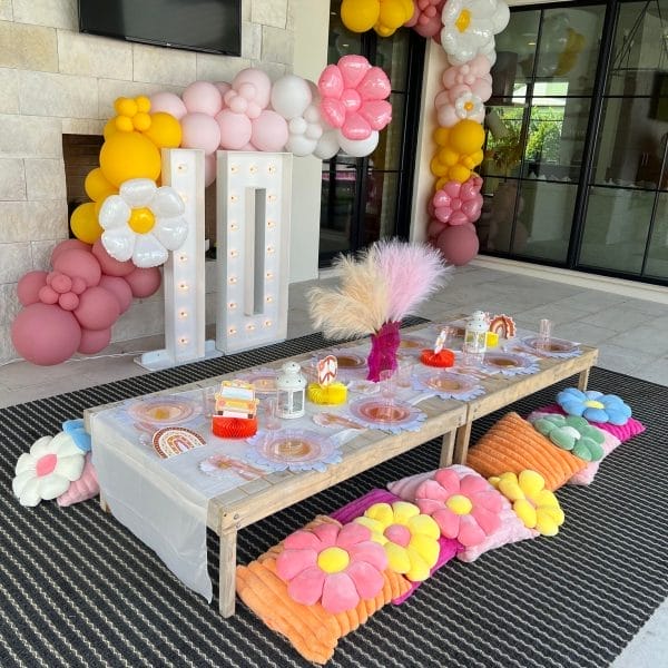 A festive birthday party set up with balloons and flowers.