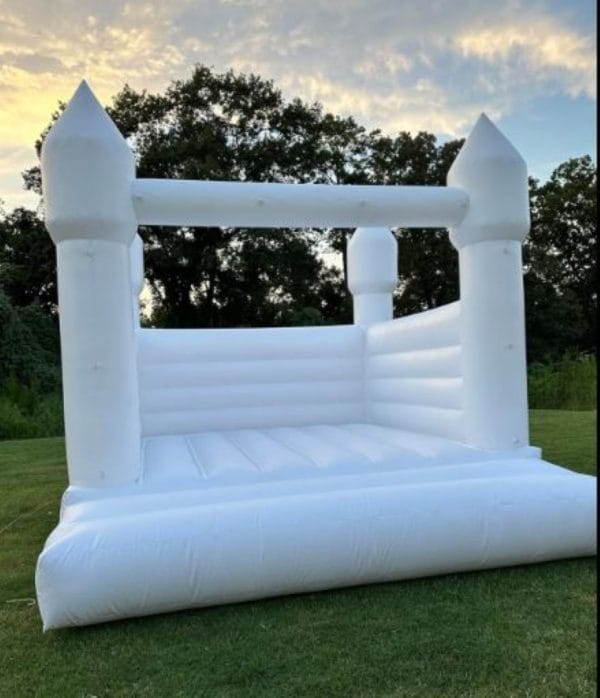Majestic White Bounce House Castle set up in a grassy area during dusk.