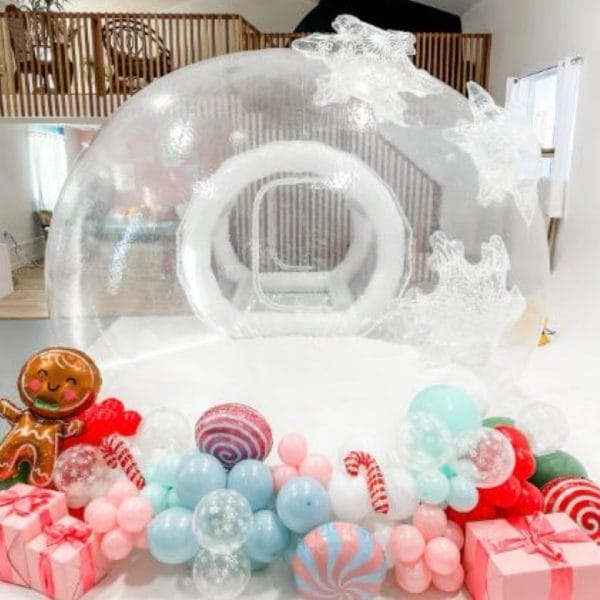 An Enchanting Bubble Balloon House Rental, perfect for a holiday party in Lakeland. This unique glamping experience is adorned with candy canes and balloons, creating a joyful atmosphere.