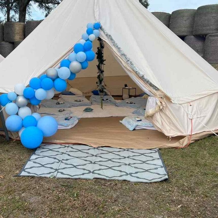A blue and white Bell Tent with balloons on it.