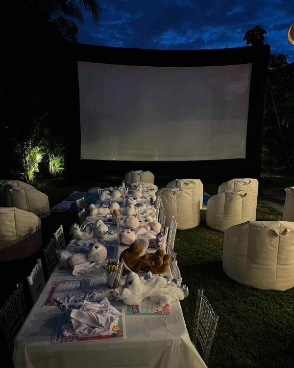 An outdoor movie screen set up for a baby shower with a teepee.