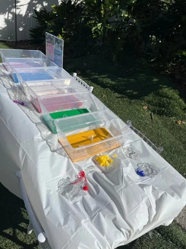 A table with plastic containers filled with different colored liquids, perfect for a Glamping setup.