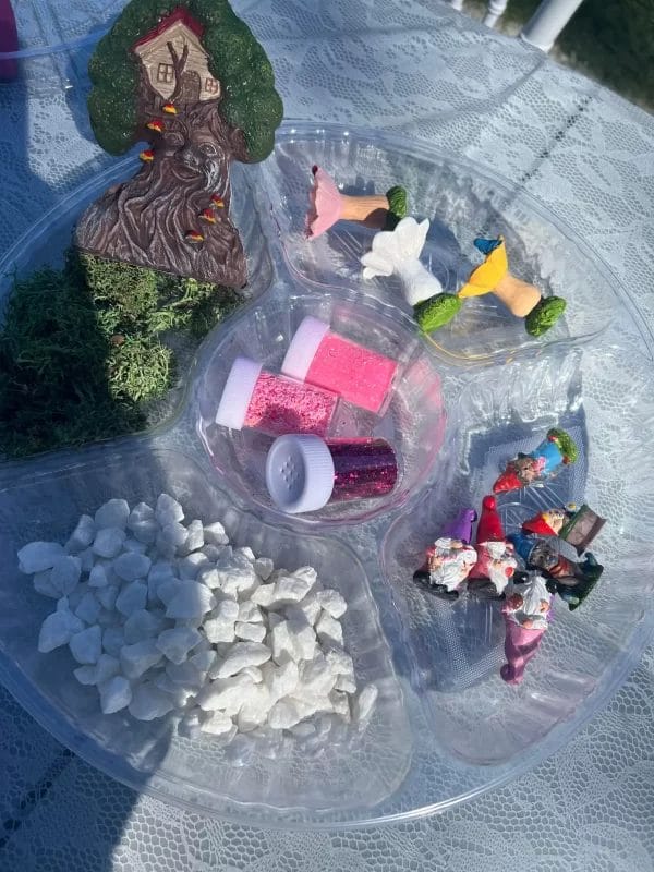 A plastic tray with fairy figurines on it, perfect for glamping.