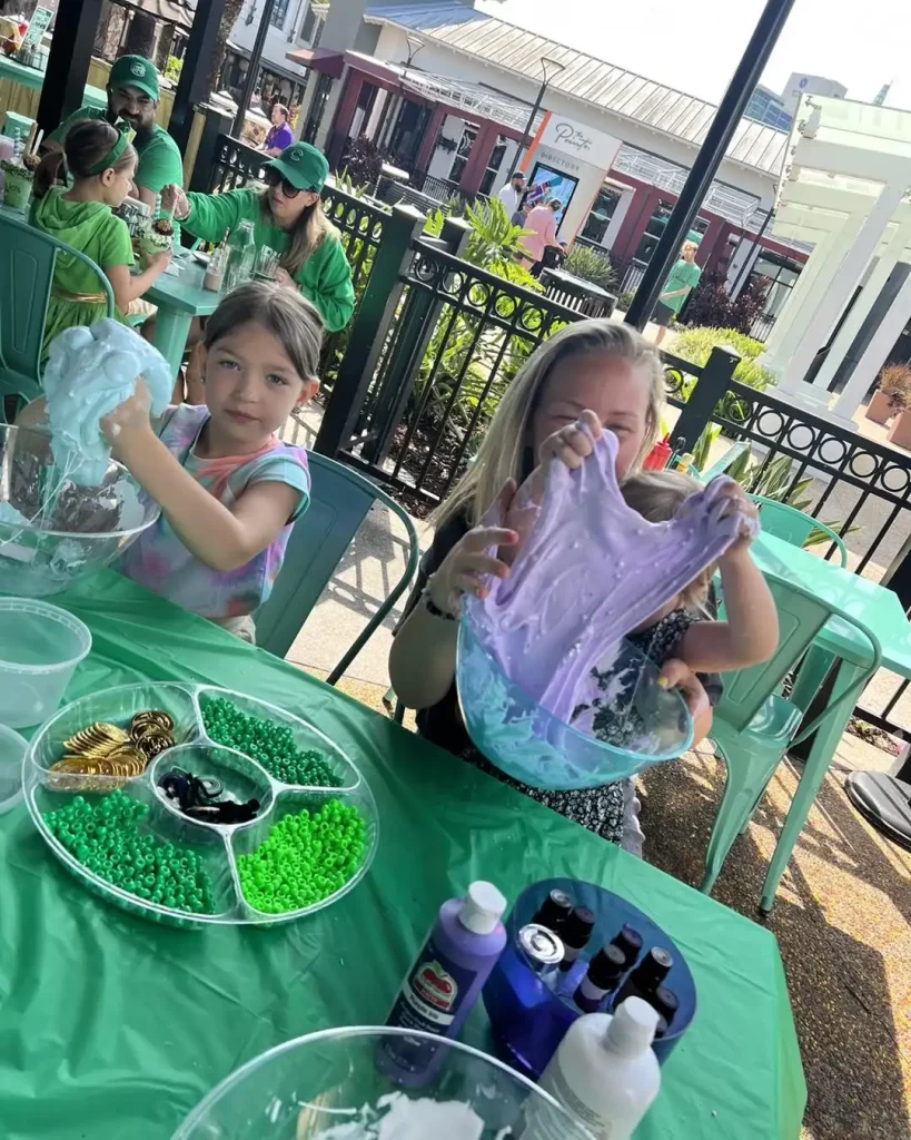 Children engaging in a slime-making activity at an outdoor event.