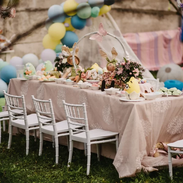 An outdoor Kids Table and Chair Rental for a children's party with pastel balloons and decorations.